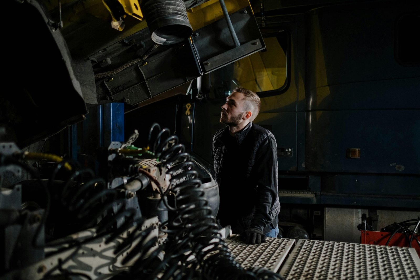 Mechanic standing and looking at a truck in the garage